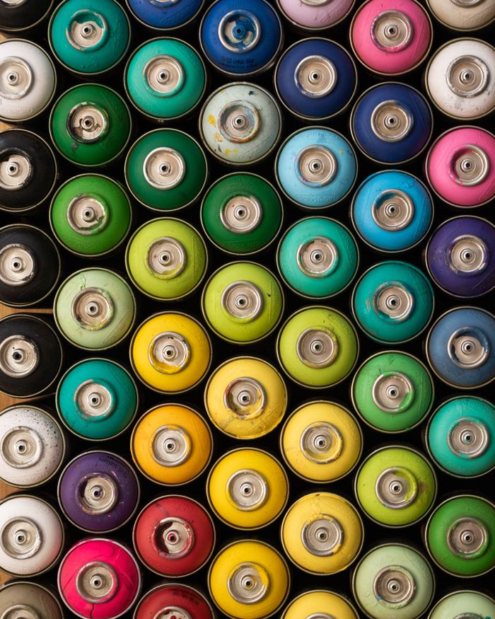 why-choose-us A vibrant collection of spray paint cans arranged in a gradient pattern, showcasing a spectrum of colors.